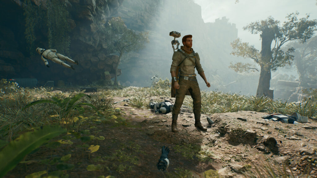 Cal stands in a woody area, with a stormtrooper hovering behind him and body parts across the ground