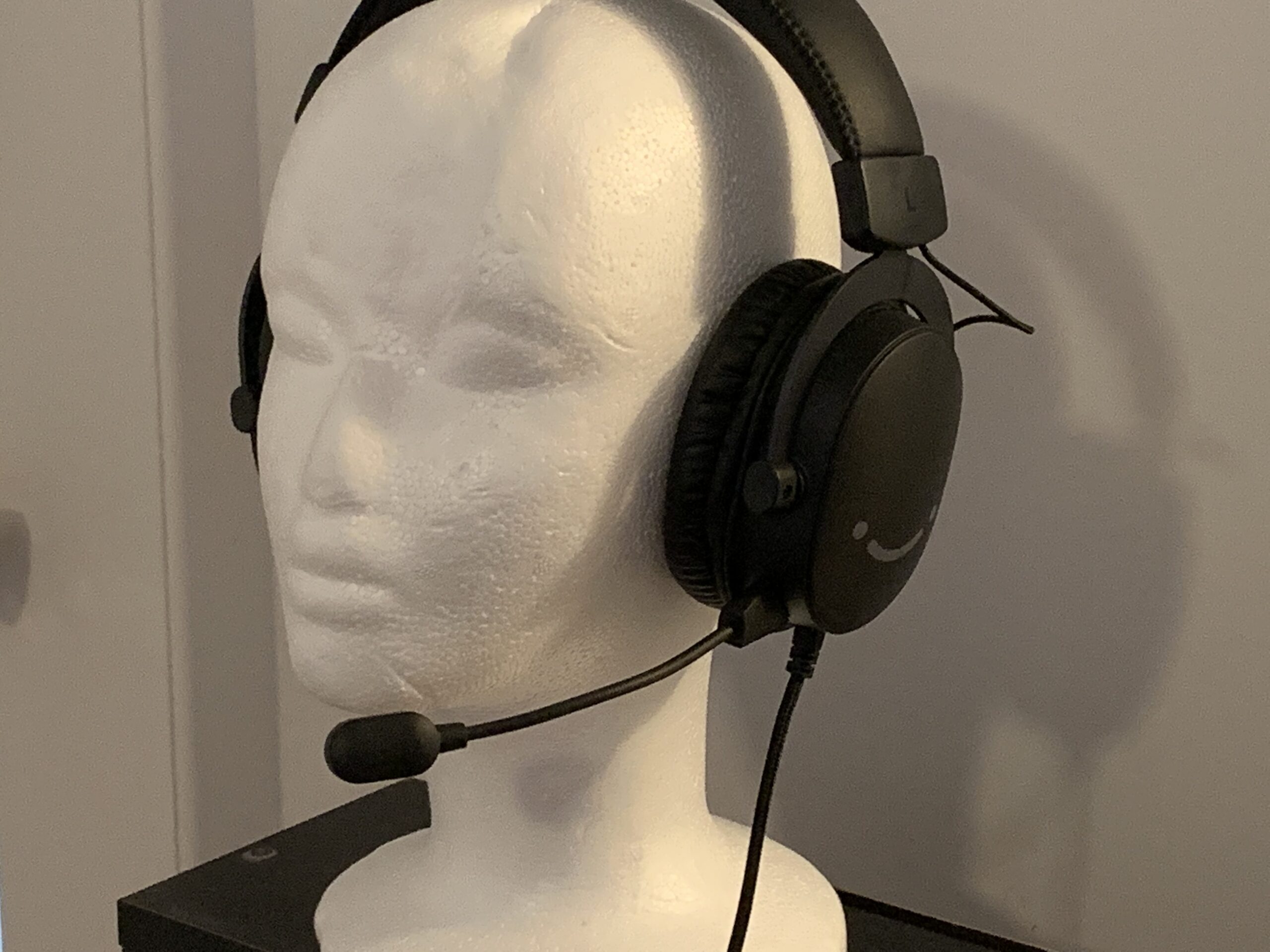A photograph of the Fifine Ampligame H9 Gaming Headset displayed on a polystyrene head bust, mix positioned in front of the bust's mouth.